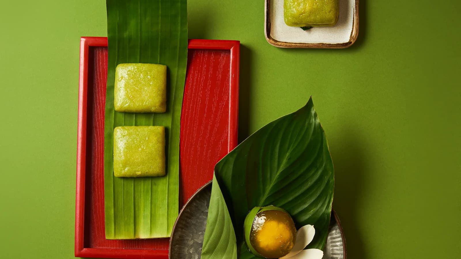 Bánh cốm đặt trên lá chuối trong khay sơn đỏ