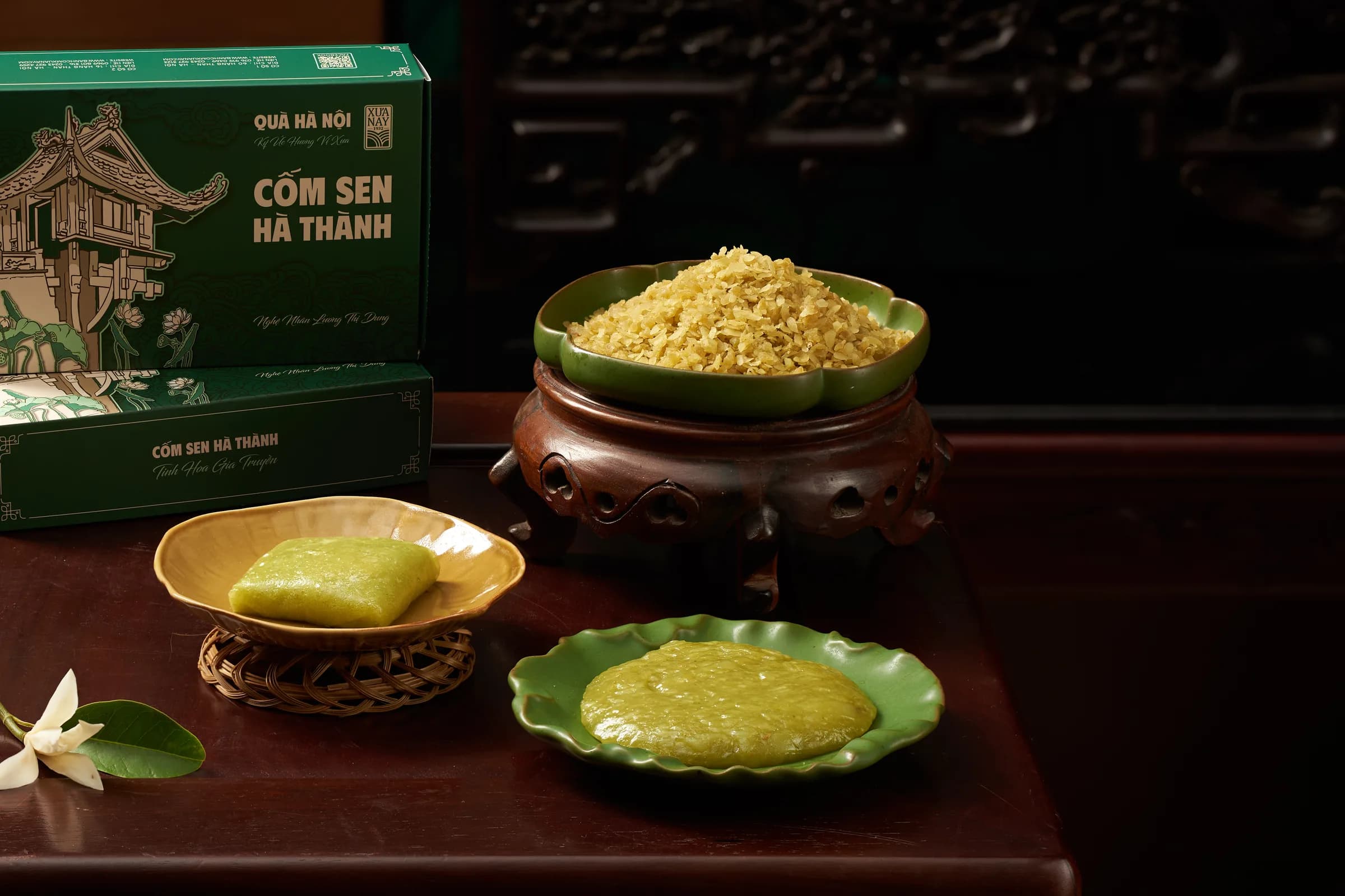 Hộp cốm sen Hà Thành bên bát cốm và hai đĩa bánh xanh